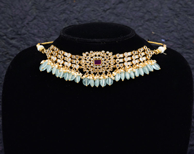 A fancy choker set with earrings desiged with blue beads and white kundan stones