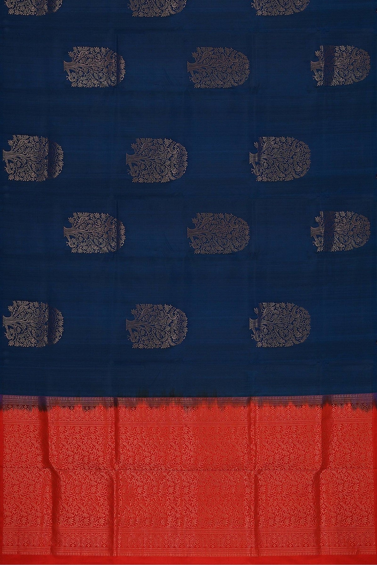 A flat representation of the handwoven soft silk saree in dark blue base and red pallu with tree motifs in gold zari.