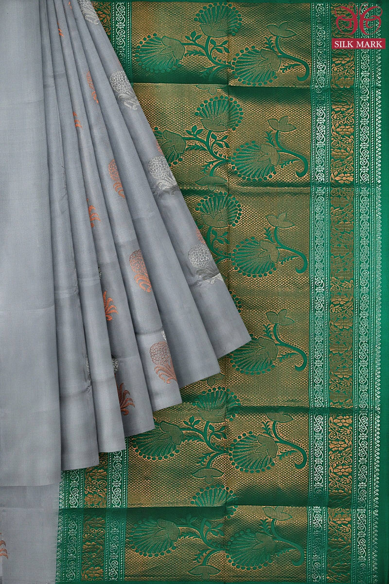 A silk marked Kanchivaram handloom saree with the body in elephant grey and pallu in teal green color with floral & plant motifs in silver & copper zari.