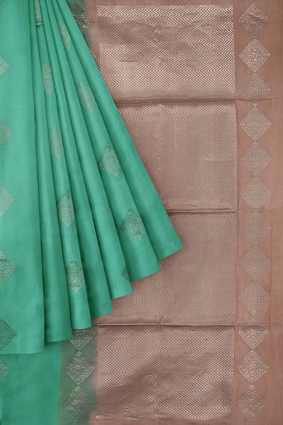 An elegant Kanchivaram handloom saree with the body in turquoise blue and pallu in pastel brown color with diamond motifs in silver zari.