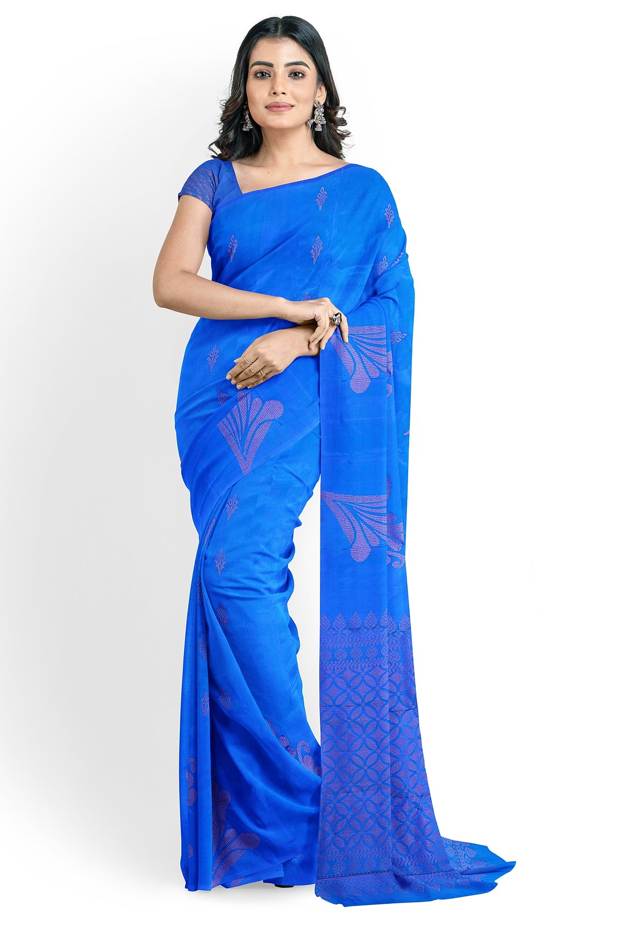 A model wearing a peacock blue soft silk handloom saree with dark blue base & pallu. The saree is designed with floral motifs in neem zari works. The saree comes with an attached running blouse.