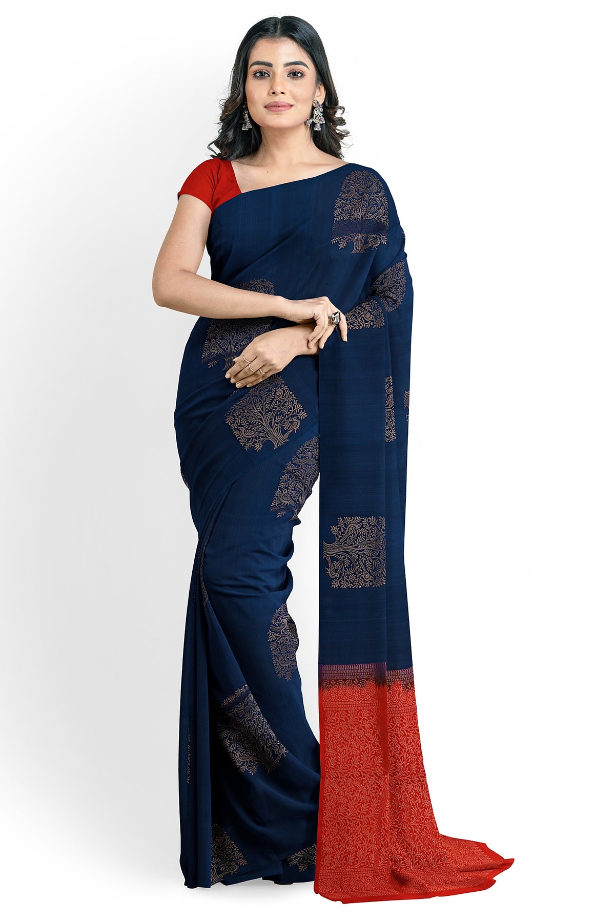 A model draped in  a unique sapphire blue soft silk handloom saree with navy blue body and ruby red pallu. The saree is designed with tree motifs in gold zari works. The saree comes with a separate blouse material.