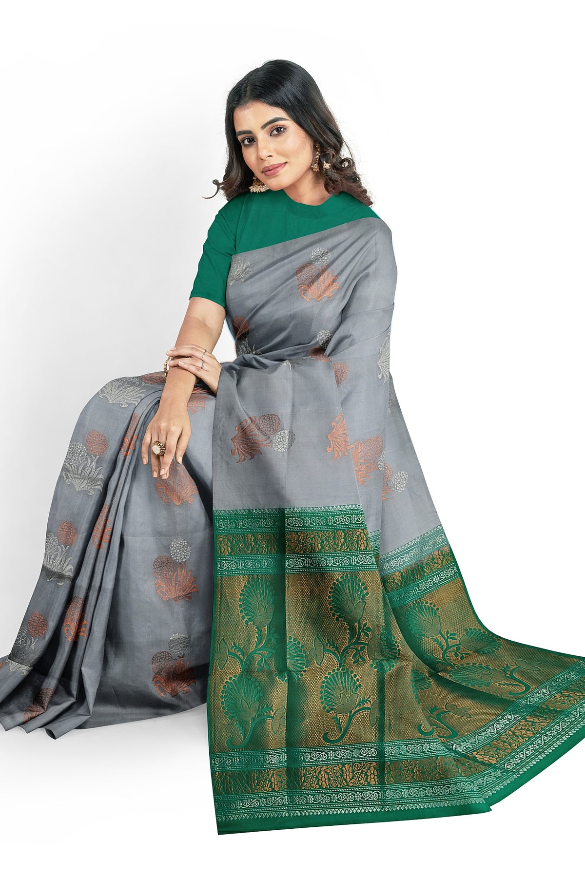 A model draped in a unique grey soft silk handloom saree with grey body and teal green pallu. The saree is designed with plant & floral motifs in silver & copper  zari works. The saree comes with a separate blouse material.