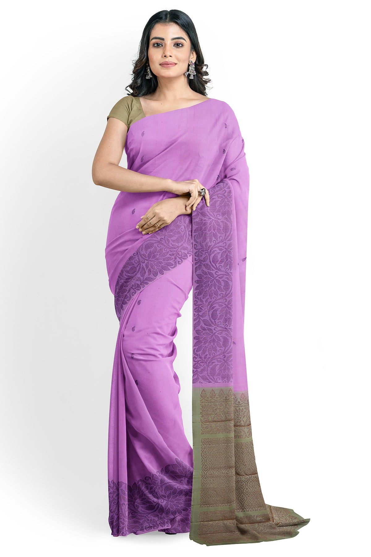A model draped in a pretty lotus pink soft silk saree with pink body,  pastel brown pallu and floral border. The saree is designed in floral & mango motifs in neem zari works. The saree comes with an attached running blouse.
