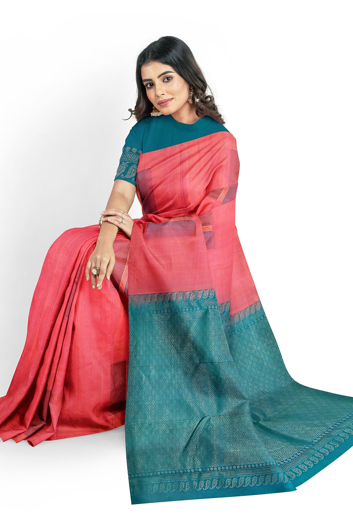 A model draped in a unique pastel pink soft silk handloom saree with pink body and teal blue pallu. The saree is designed with dual color glitter motifs in neem zari works. The saree comes with an attached running blouse.